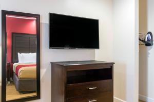a bedroom with a flat screen tv and a mirror at Econo Lodge Inn & Suites Houston Willowbrook in Houston