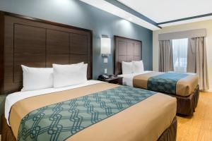 a hotel room with two beds and a window at Econo Lodge Inn & Suites Houston Willowbrook in Houston