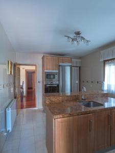 a kitchen with wooden cabinets and a sink at Casa El Descanso Ortigosa del Monte in Ortigosa del Monte