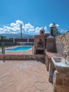 a patio with a brick oven next to a pool at Casa El Descanso Ortigosa del Monte in Ortigosa del Monte
