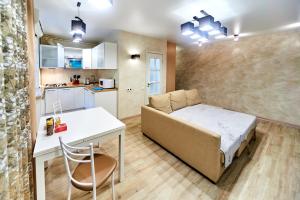スモレンスクにあるАпартаменты на проспекте Гагаринаのベッド、デスク、キッチンが備わる小さなアパートメントです。