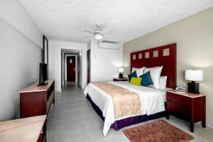 
a hotel room with a bed and a dresser at El Cid La Ceiba Beach in Cozumel
