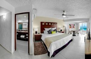 a bedroom with a large bed and a living room at El Cid La Ceiba Beach in Cozumel +31 photos
