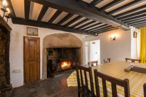 a dining room with a table and a fireplace at Hallagather Farmhouse in Crackington Haven