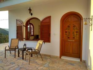 a room with two chairs and a table and a door at Gabriel residence in Kardhakáta