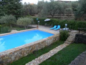 a swimming pool with a stone wall around it at La Dolce Vita Country House with pool - Solicchiata in Castiglione di Sicilia