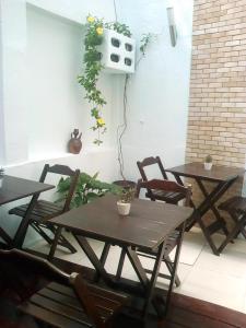 two tables and chairs on a patio with plants at Hotel Pousada Catarina Mina in São Luís