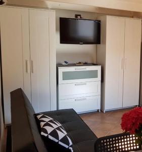 Mini Loft Porto Torres في بورتو توريس: غرفة معيشة مع أريكة وتلفزيون بشاشة مسطحة