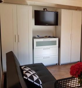 a living room with a couch and a flat screen tv at Mini Loft Porto Torres in Porto Torres