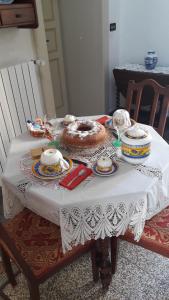 - une table avec un gâteau et de la vaisselle dans l'établissement Casa Millenovecento, à Brindisi