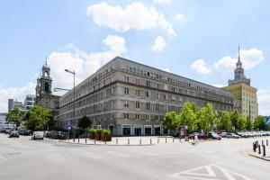 ワルシャワにあるVIVE City Center for fourの駐車場車を停めた灰色の大きな建物
