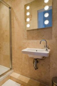 a bathroom with a sink and a mirror and a shower at Historic Edinburgh 1890s Home Turned Relaxing Retreat in Edinburgh