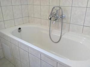 eine weiße Badewanne mit Dusche im Badezimmer in der Unterkunft Apartments Zvonimir,place by the sea in Mirce + 43 Fotos