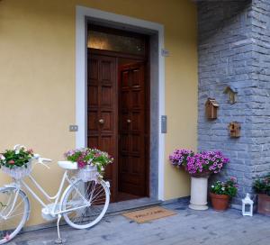 biały rower zaparkowany przed domem z kwiatami w obiekcie aMarti Suites B&B w mieście Santo Stefano di Magra