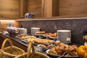 ein Buffet mit vielen verschiedenen Brotsorten und Gebäck in der Unterkunft Ariston Lake View Hotel in Molveno