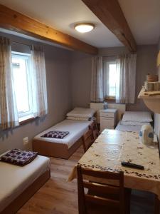 ダルウォボにあるAgroturystyka Stokrotkaのベッド3台、テーブル、椅子が備わる客室です。