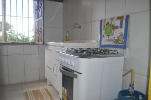 uma cozinha branca com um forno com placa de fogão em Sitio Os Tres em Camaçari