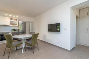 eine Küche und ein Esszimmer mit einem weißen Tisch und Stühlen in der Unterkunft Kiwi in Trogir