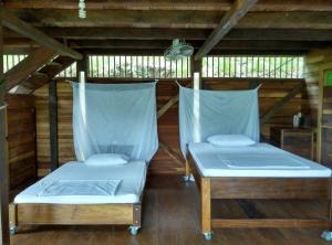 two beds in a room with wooden floors at Cabana El Caney in Sapzurro