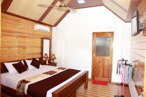 a bedroom with a bed and a ceiling fan at Elegant Green Beach Resort in Trincomalee