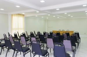 an empty room with purple chairs and a podium at Brivali Hotel Centro in Caçador