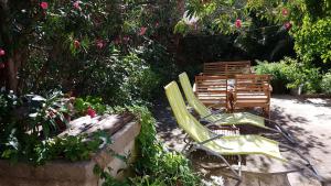 dos sillas de césped y un banco en un jardín en Holiday Home Shangri-La, en Milna