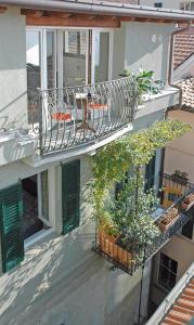 a balcony with chairs and plants on a building at Charming Bellagio in Bellagio
