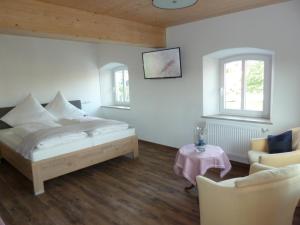 um quarto com uma cama, 2 cadeiras e uma mesa em Ferienwohnung zum Dorfwirt em Riedenburg