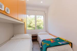 a small bedroom with two beds and a window at Piso luminoso en Barcelona in Barcelona