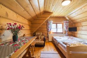 Dormitorio en cabaña de madera con cama y sofá en Pokoje gościnne "U Teresy", en Krościenko nad Dunajcem