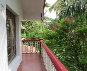einen Balkon eines Hauses mit rotem Geländer in der Unterkunft Maison Casero Home Stay in Kochi