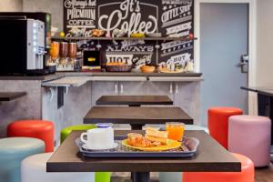 a table with a plate of food and drinks on it at Welcomotel Les Mureaux in Les Mureaux