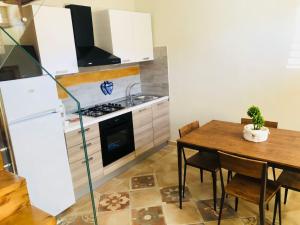 a kitchen with a table and a white refrigerator at Simone Home in Roccella Ionica