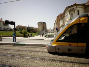 un tren blanco y amarillo en una calle de la ciudad en Apartamento Alvares Cabral, en Vila Nova de Gaia