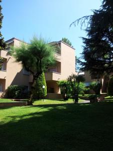un edificio con un albero in mezzo a un cortile di Residence La Madonnina a Peschiera del Garda