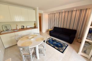 a kitchen and a living room with a table and a couch at Apartment Maniva in Kotor