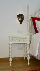 a white bedside table with a lamp next to a bed at Casinhas da Ajuda nº 29 in Lisbon