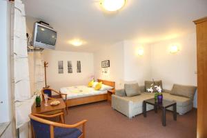 a living room with a bed and a couch at Pension Harrachov in Harrachov