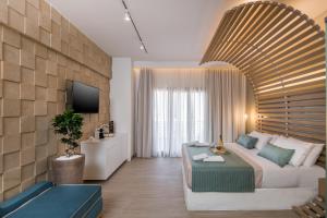 een woonkamer met een bank en een tv bij Agave Suites in Chania