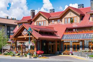a large wooden building with a red roof at Banff Ptarmigan Inn in Banff
