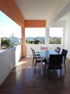 a dining room with a table and chairs on a balcony at Apartments Mira in Bibinje