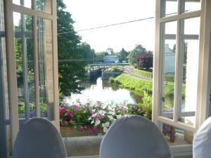 einen Blick auf den Fluss von einem Fenster mit Stühlen in der Unterkunft Villa Tranquillité in Rohan