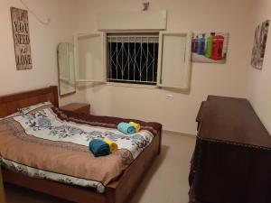 1 dormitorio con cama y ventana en 3 Stairs Only to Cozy Flat on Hillel st, en Haifa