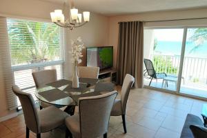 a dining room with a table and chairs and a television at Beach and sunset view from your balcony in Longboat Key