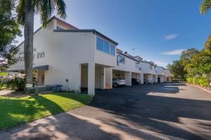 a row of buildings with cars parked in the driveway at Noosa Parade Holiday Inn in Noosa Heads