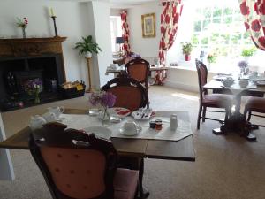 une salle à manger avec une table, des chaises et une cheminée dans l'établissement Park Farmhouse Bed and Breakfast, à Washaway