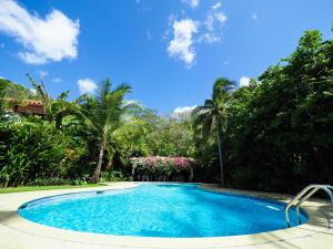 a swimming pool in a yard with palm trees at Hotel Playa Cambutal in Cambutal
