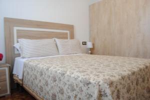 a bedroom with a large bed with white sheets and pillows at Casa La Torre in Isla de Arosa