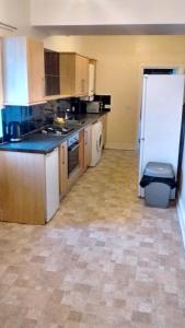 an empty kitchen with a white refrigerator in a room at Derwent Street Apartment 1 - 3 Bed Self Catering Apartment - Self Contained - 1 Double & 2 Single Rooms in Workington