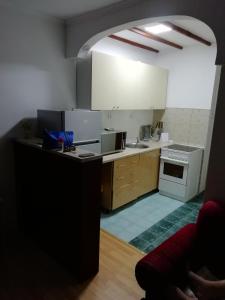a kitchen with white cabinets and a stove top oven at apartman holiday budva in Budva